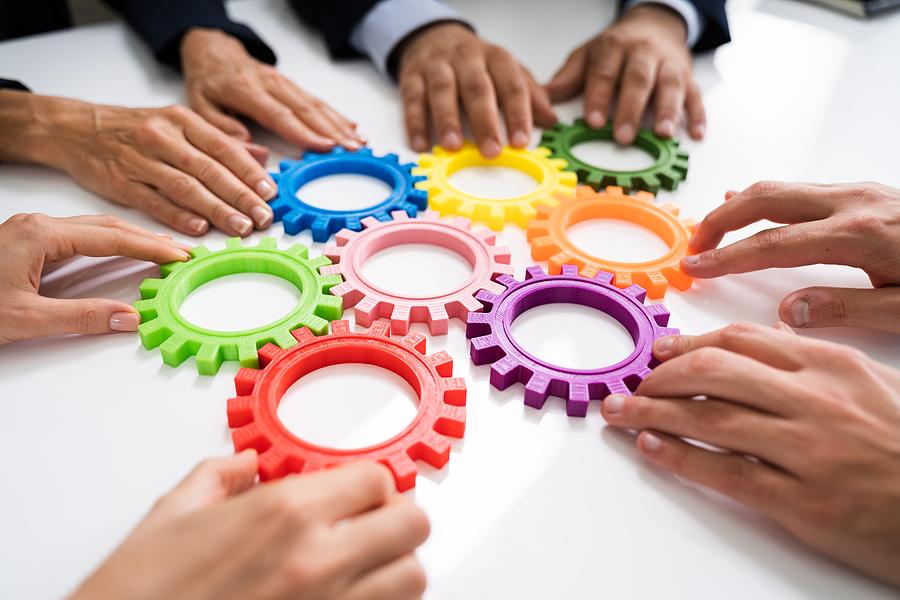 Team members work together like gears pressed together on a table.