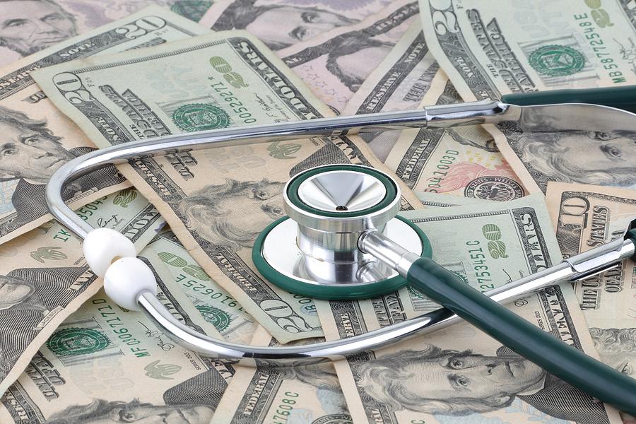 Medical stethoscope on a pile of money signifying the relationship of money and medicine