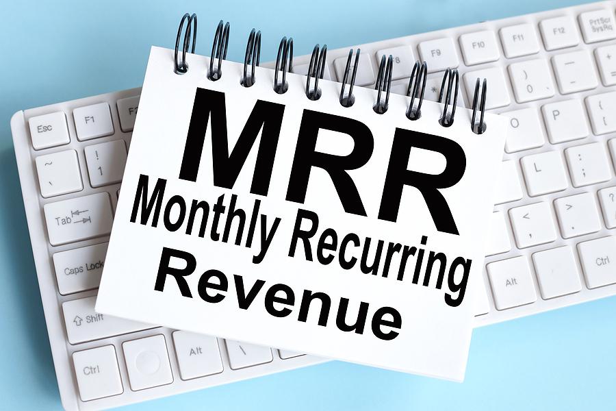MRR Monthly Recurring Revenue. text on white notepad paper on white keyboard